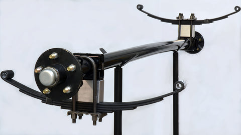 Trailer axle with leaf springs mounted above and below the axle